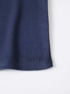 Close-up detail of mens navy blue waffle knit fabric, soft texture for casual long sleeve top.