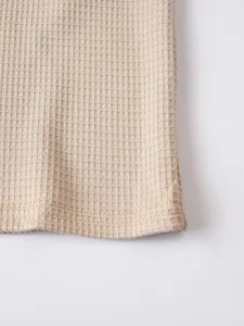 Waffle knit fabric texture detail, close up view of casual long sleeve t-shirt hem.