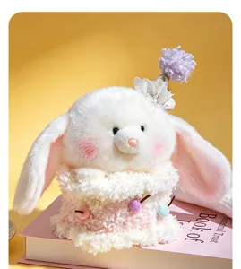 Close-up detail of the cute white plush rabbit doll with party hat in cake base display.
