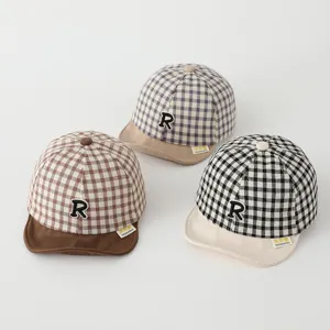 Detail view of cute baby baseball caps in brown, grey and black plaid with soft brim.