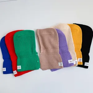 Detail shot of colorful knitted children balaclava hats in various vibrant solid colors.