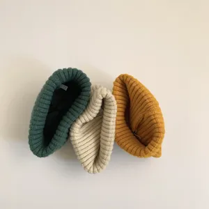Detailed shot of cozy kids ribbed knit beanie hats in green, beige and yellow colors.