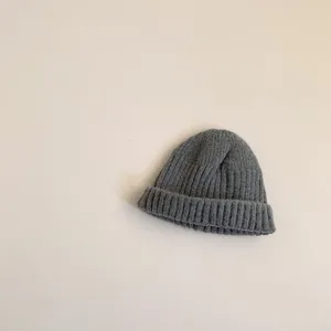 Detailed shot of grey ribbed knit beanie showing soft wool texture and fine craftsmanship.