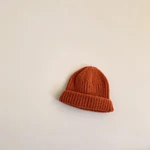 Detailed close-up of the autumn winter children knit beanie hat in rust brown color option.