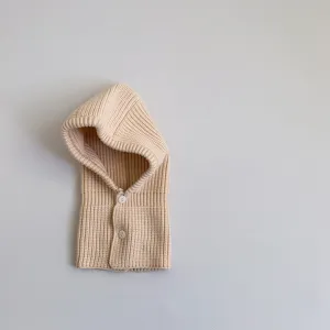 Detailed view of a cozy baby knit balaclava in beige, featuring fine ribbed texture and buttons.
