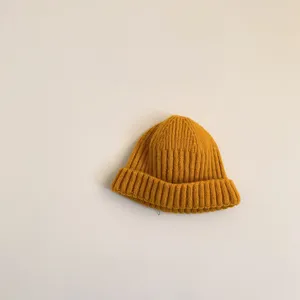 Detailed close-up of a cozy yellow knitted beanie, soft texture and warm winter style.