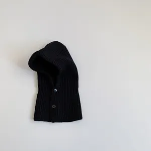 Close-up of black knitted baby balaclava, ribbed texture, winter warm hood scarf detail.