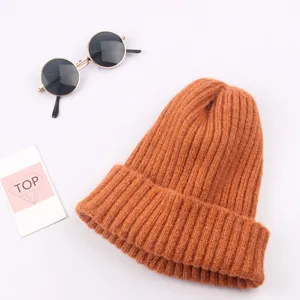 Dettaglio berretto in maglia arancione, materiale a coste morbido, comodo cappello invernale bimbi.