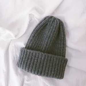 Children knitted beanie detail shot, dark grey warm winter hat close-up showing soft texture.