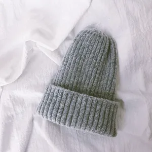 Detail shot of soft grey knitted children beanie showing rib texture and warm cozy material.