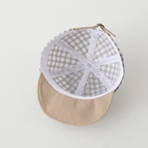 Detailed view of baby plaid baseball cap interior, soft brim infant sun hat design.