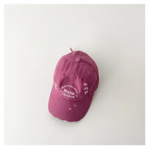Close up view of the purple distressed children baseball cap with white embroidered text.