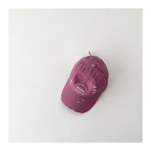 Close-up detail of the vintage distressed kids baseball cap with white letter embroidery.