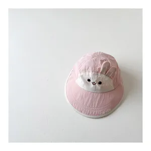 Detail shot of cute pink baby sun hat with bunny ears and quick-drying fabric for summer.