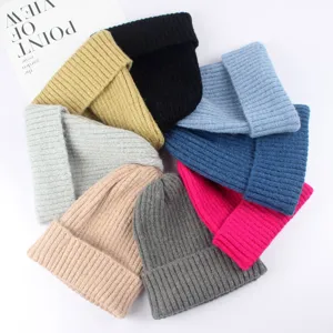 Primo piano di un set di berretti invernali in maglia colorata, cuffie a coste morbide e calde.