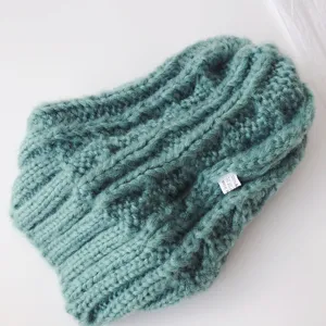 Close up view of the cozy knitted kids beanie with texture details and a small brand label.