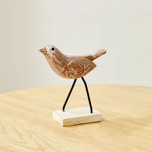 Minimalist wooden bird figurine statue sculpture home decor ornament on metal legs tabletop.
