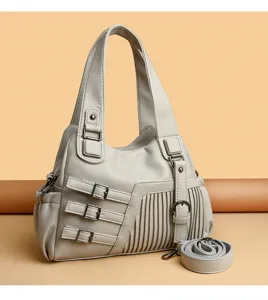 Graue weiche Leder Schultertasche fuer Damen mit dekorativen Schnallen und Falten.