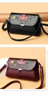 Detailaufnahme der eleganten Damenumhängetasche aus Leder mit klassischer Blumenprägung.