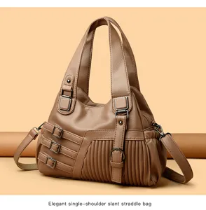 Braune Schultertasche aus Kunstleder mit dekorativen Schnallen, Falten und doppelten Griffen.