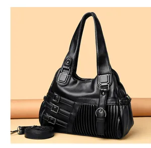 Schwarze Damen Umhängetasche aus weichem Leder, lässige Handtasche mit Griffen und Gurt.