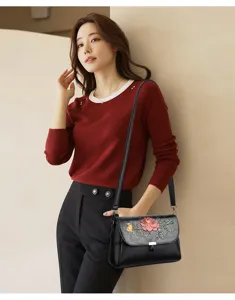 Eleganter Schultertaschen-Detailshot aus Leder mit Blumenstickerei und feiner Verarbeitung.