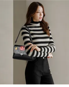Elegante schwarze Damentasche aus Leder mit Blumenstickerei und praktischem Schultergurt.