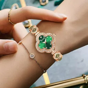 Elegant women's green clover quartz watch with rose gold rhinestone strap wrist detail.