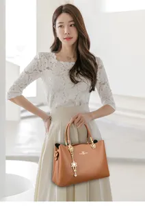 Elegante braune Handtasche mit grossem Fassungsvermoegen fuer Damen mit Metallanhaenger.