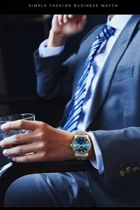 Close-up detail shot of business quartz watch with steel strap worn by model in suit.
