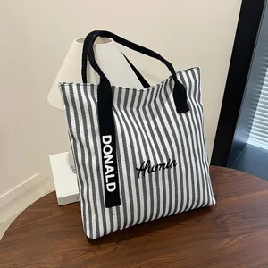 Black and white striped canvas tote bag, large capacity shoulder handbag for daily commute.