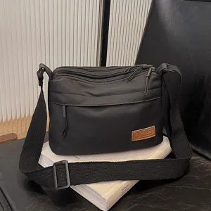 Unisex black multi-layer canvas crossbody bag, casual simple shoulder bag with large capacity.