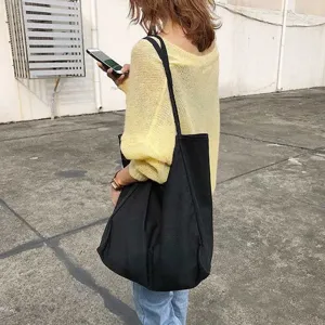 Minimalist black canvas tote bag for women, large capacity casual shoulder bag for daily use.