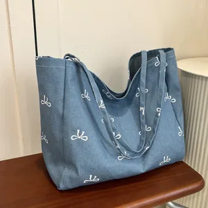 Blue denim canvas tote bag with cute white bow print, large capacity casual shoulder bag.
