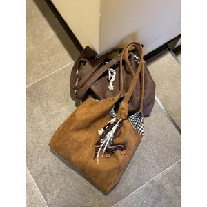 Brown faux suede shoulder tote bag with dog charm and check lining for women daily use.