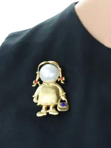 Spilla vintage bambina oro opaco dettaglio, testa di perla e accenti di strass luminosi.