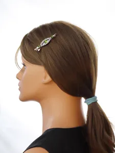 Vintage Haarspange mit grünen Strasssteinen und silbernem Metall für elegante Damenfrisuren.