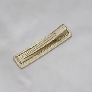 Golden metal duckbill hair clip close-up, elegant design for daily styling and bangs decoration.