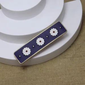 Close-up detail of the vintage dark purple enamel hair clip featuring three white daisy flowers.