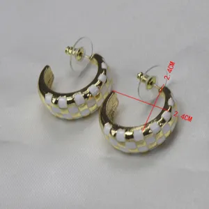 Vue détaillée de boucles d'oreilles créoles en émail quadrillé or et blanc vintage français chic.