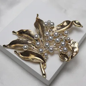 Vintage gold-tone leaf brooch with pearls and rhinestones detail shot for elegant apparel.