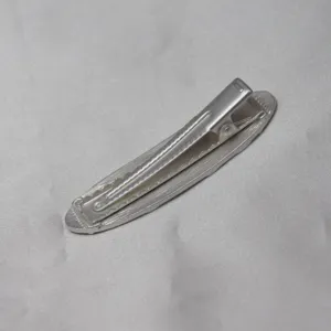 Detailed close-up view of a vintage silver hair clip showing its secure snap mechanism.