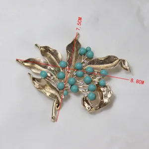 Vintage style gold-tone leaf and turquoise bead rhinestone brooch detail view for apparel.