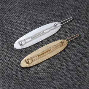 Detail shot of French retro style metal hair clips with elegant oval relief design and pins.