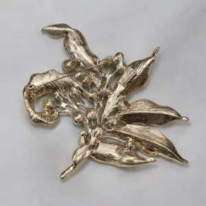 Vintage gold tone floral brooch back detail showing secure pin clasp and brand hallmark.