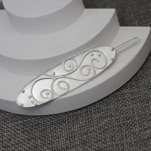 Close-up detail shot of vintage French style silver side hairpin with intricate scroll relief.