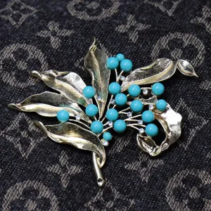 Vintage gold-tone leaf brooch with turquoise beads and rhinestones, detailed jewelry accessory.