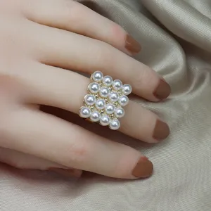 Gros plan vue détail de bague design matrice multi perles sur bande or ajustable.