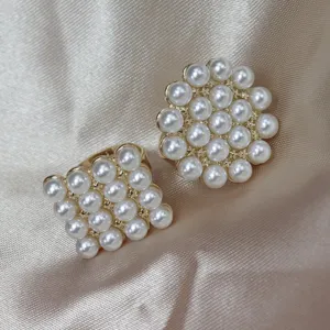 Gros plan détaillé des bagues ouvertes élégantes plaquées or avec des perles.