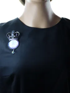 Detailed close-up of a vintage silver crown moon face brooch with colorful rhinestones.